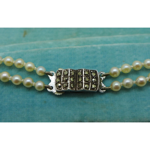 863 - A double strand of cultured pearls with silver clasp