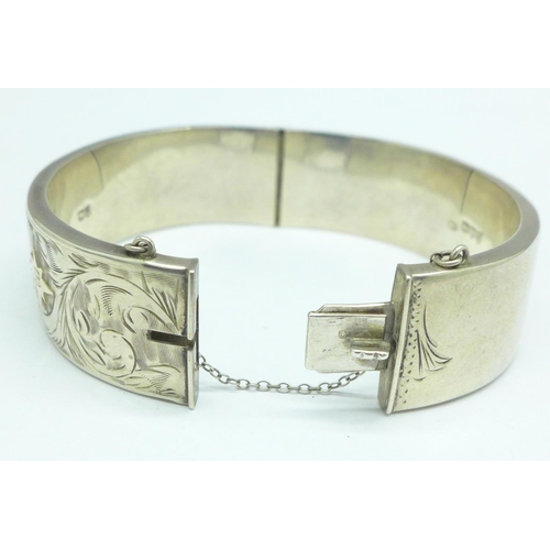 989 - A silver bangle with gold applied decoration, 29g