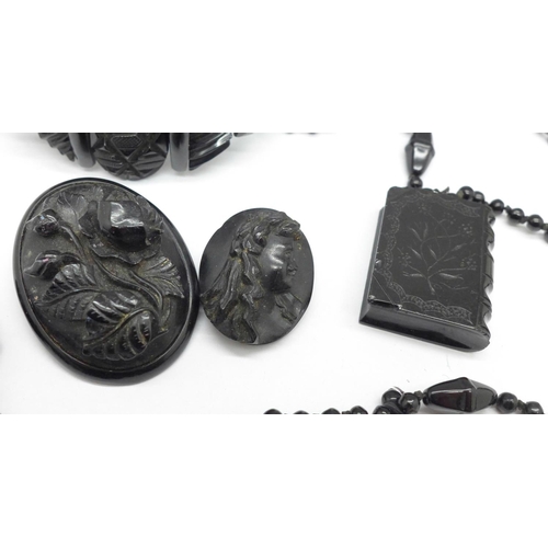 992 - A Whitby jet 'book' pendant, two brooches and bracelet, and a black bead necklace, requires repair