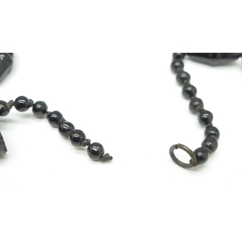 992 - A Whitby jet 'book' pendant, two brooches and bracelet, and a black bead necklace, requires repair