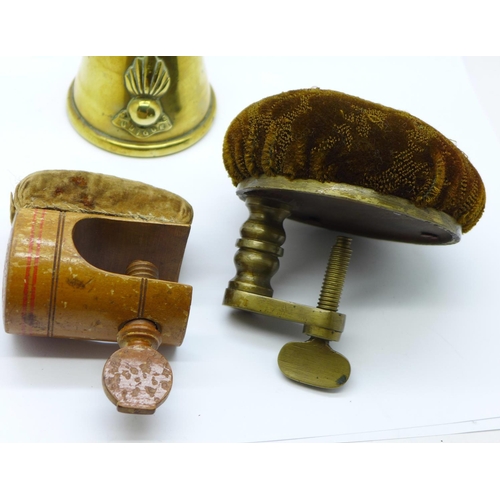 635 - A 19th Century treen table fastening pin cushion, a table fastening pin cushion and a brass trench a... 