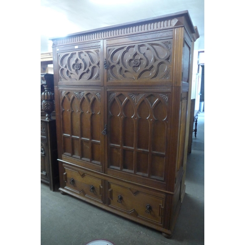 108 - An Elizabethan style carved oak fitted press cupboard