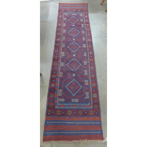 114 - A hand knotted red ground runner rug, 258 x 63cm