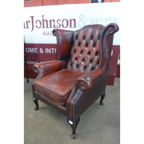 91 - A red leather wingback armchair