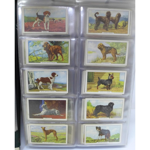 680 - An album of fourteen complete sets of cigarette cards, an album of nine sets of trade cards and two ... 