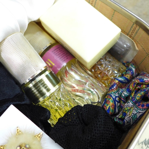 699 - A suitcase containing clothing, babywear, gloves, Christening gowns, etc.