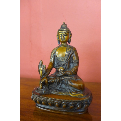 90 - A small oriental bronze figure of a seated deity