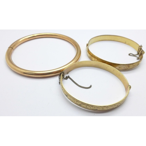 1104 - A 9ct gold, bronze core bangle and two rolled gold bangles