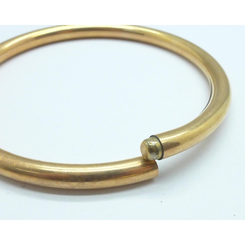 1104 - A 9ct gold, bronze core bangle and two rolled gold bangles