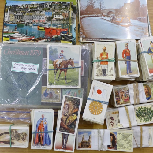 713 - A collection of cigarette cards, etc., and nine commemorative mint stamp packs