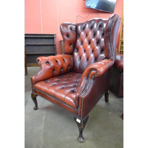 112 - A red leather Chesterfield wingback armchair