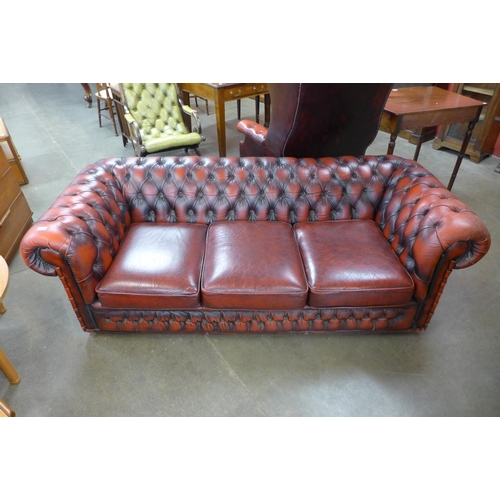 114 - A red leather Chesterfield settee