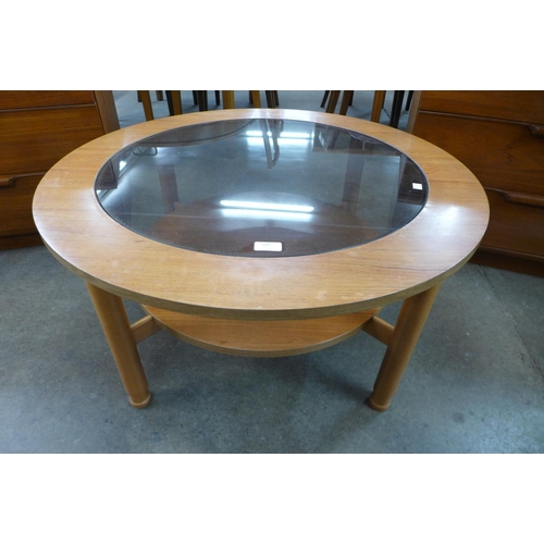 145 - A teak and glass topped circular coffee table