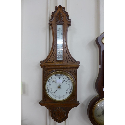 56 - A Victorian carved oak aneroid barometer