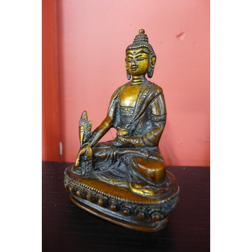 90 - A small oriental bronze figure of a seated deity