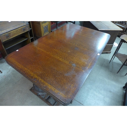 99 - A carved oak draw-leaf table