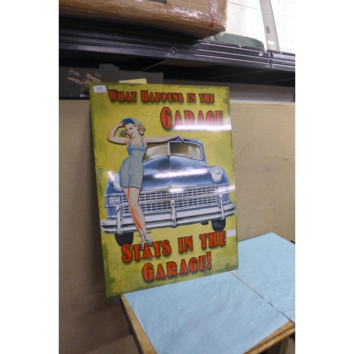 2078 - Large tin plate sign - What Happens In The Garage *This lot is subject to vat