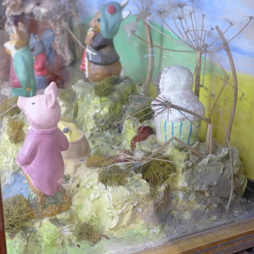 681 - A Beatrix Potter Peter Rabbit shop display diorama containing eight figures, in a glass display case... 