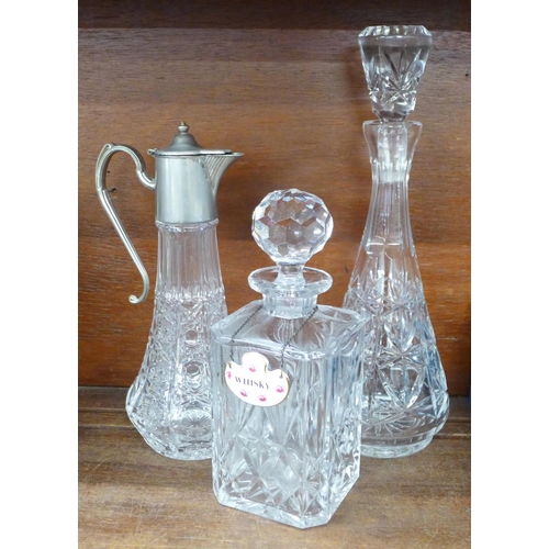 712 - A glass claret jug and two crystal glass decanters, one with a Royal Adderley whisky label