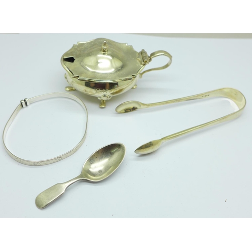 865 - A silver mustard with liner, a pair of Victorian silver sugar bows, a small silver caddy spoon and a... 