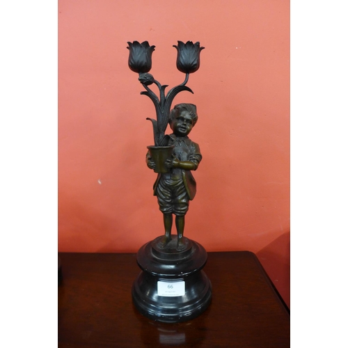 66 - A French style bronze figure of a boy holding flowers, on black marble socle