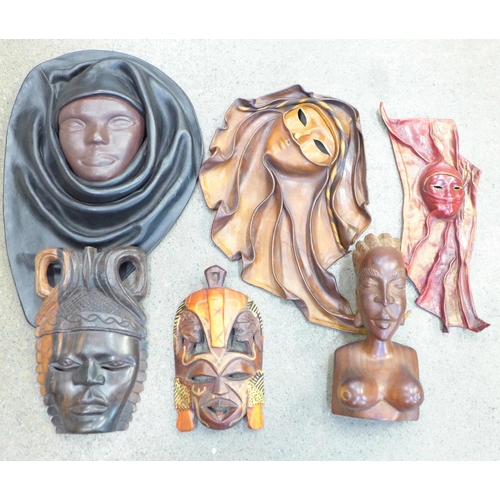 763 - An African carved bust, wall plaques, Dominican Republic leather wall mounted masks, etc.