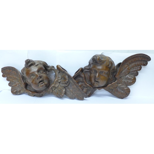 815 - A pair of early 20th Century French carved wooden cherub wall hangings