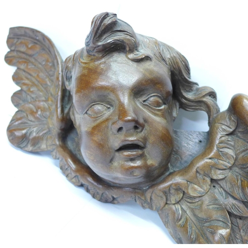 815 - A pair of early 20th Century French carved wooden cherub wall hangings