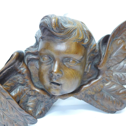 815 - A pair of early 20th Century French carved wooden cherub wall hangings