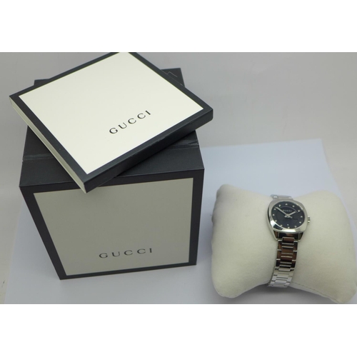 852 - A lady's Gucci stainless steel wristwatch with diamond set markers, with box and booklet