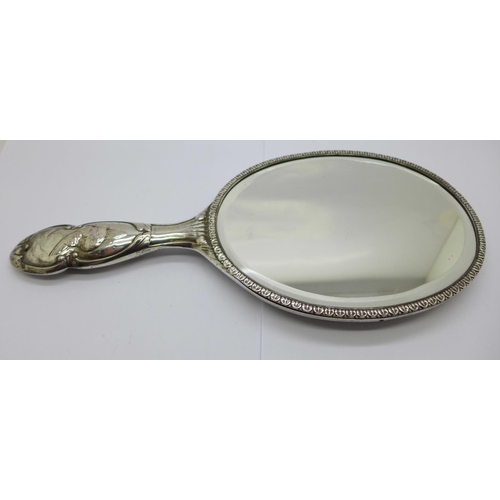 876 - A silver backed mirror with Reynolds angels, by William Comyns