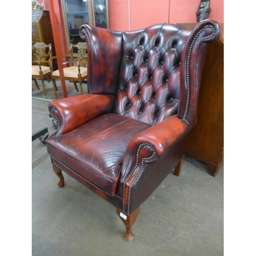 105 - A beech and red leather Chesterfield wingback armchair