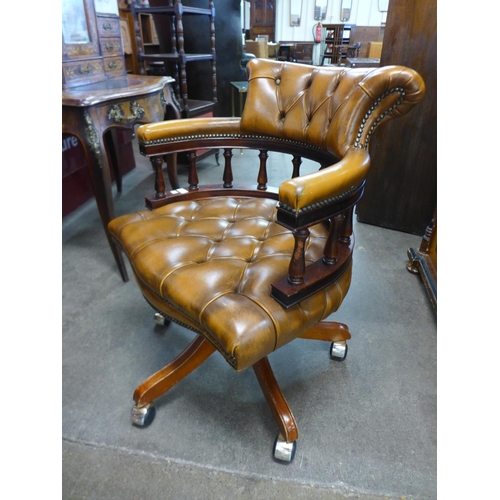 91 - A mahogany and brown leather desk chair