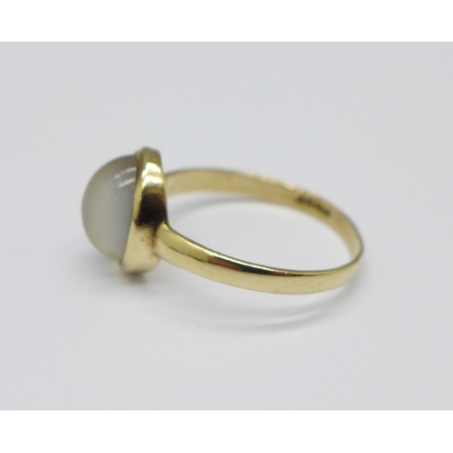 699 - A 9ct yellow gold and moonstone ring, the cabochon cut moonstone displaying cats eye effect, in rub ... 