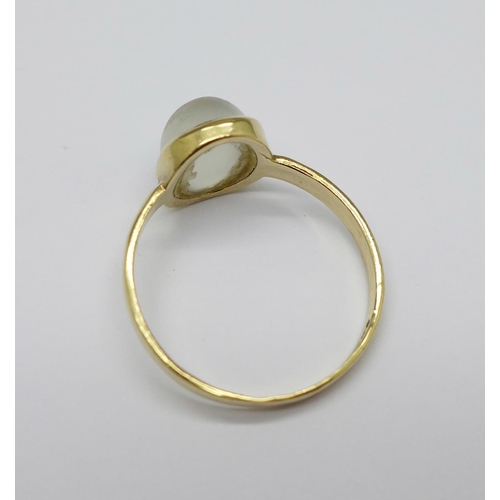 699 - A 9ct yellow gold and moonstone ring, the cabochon cut moonstone displaying cats eye effect, in rub ... 