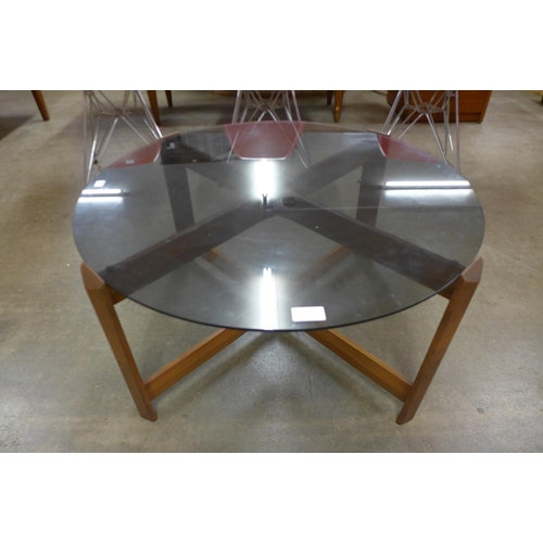 151 - A teak and glass topped circular coffee table