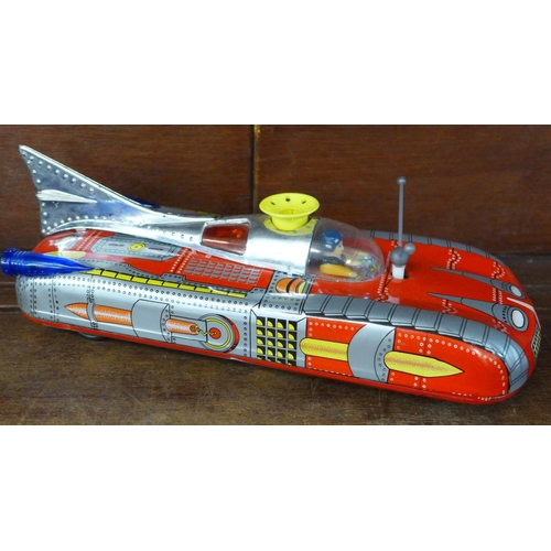 715 - A battery operated tin-plate space rocket car, (lacking 'ping-pong' ball), and two novelty toffee ti... 