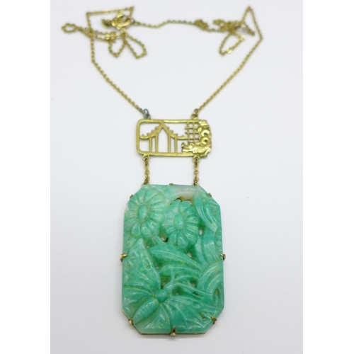 969 - A Chinese carved jade necklet on a plated chain, 39mm x 26mm