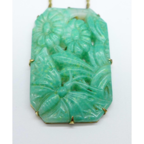 969 - A Chinese carved jade necklet on a plated chain, 39mm x 26mm