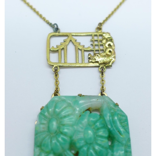 969 - A Chinese carved jade necklet on a plated chain, 39mm x 26mm