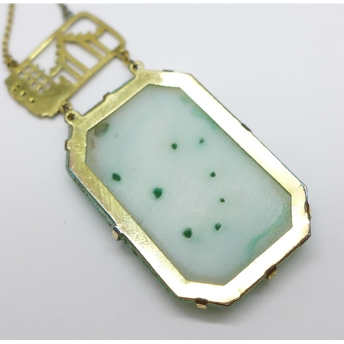 969 - A Chinese carved jade necklet on a plated chain, 39mm x 26mm