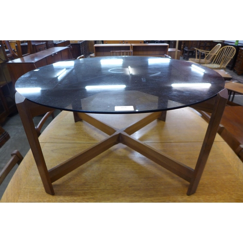 151 - A teak and glass topped circular coffee table