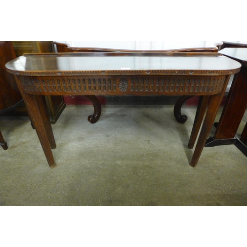 180 - A carved oak demi-lune hall table