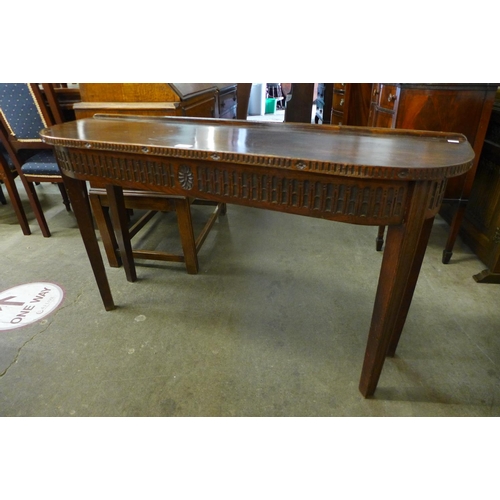 180 - A carved oak demi-lune hall table