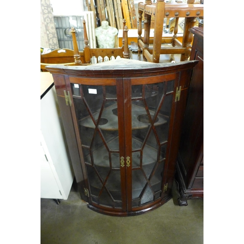 266 - A George III mahogany bow front hanging corner cupboard