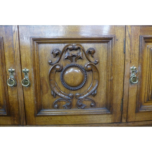 39 - An Arts and Crafts carved oak mirrorback sideboard