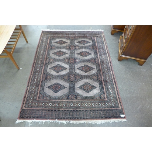 58 - An eastern terracotta ground rug, 174 x 126cms