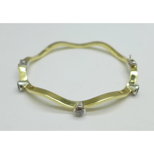 1056 - A 14ct gold, peridot and white sapphire bangle, 9.0g