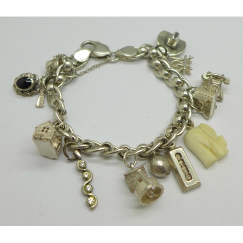 1060 - A silver charm bracelet with twelve charms, 40g, (one charm not silver)