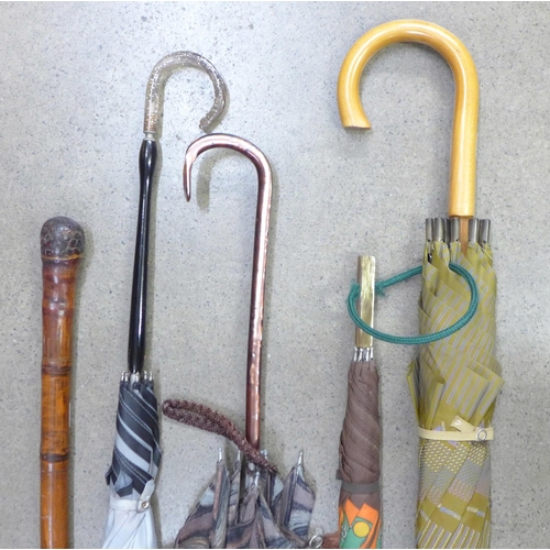 783 - Four vintage umbrellas, three with plastic handles and a bamboo cane with oriental carving